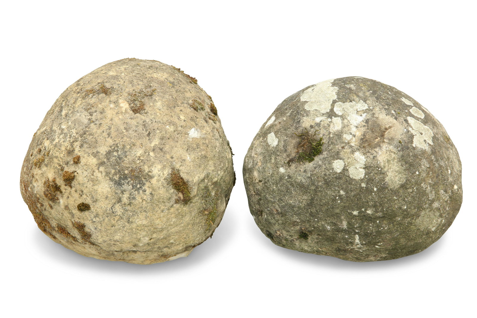 TWO WEATHERED STONE BALUSTER TREBUCHET PROJECTILES,: TWO WEATHERED STONE BALUSTER TREBUCHET PROJECTILES, later used as finials. (2) Largest approximately 22.5cm wide