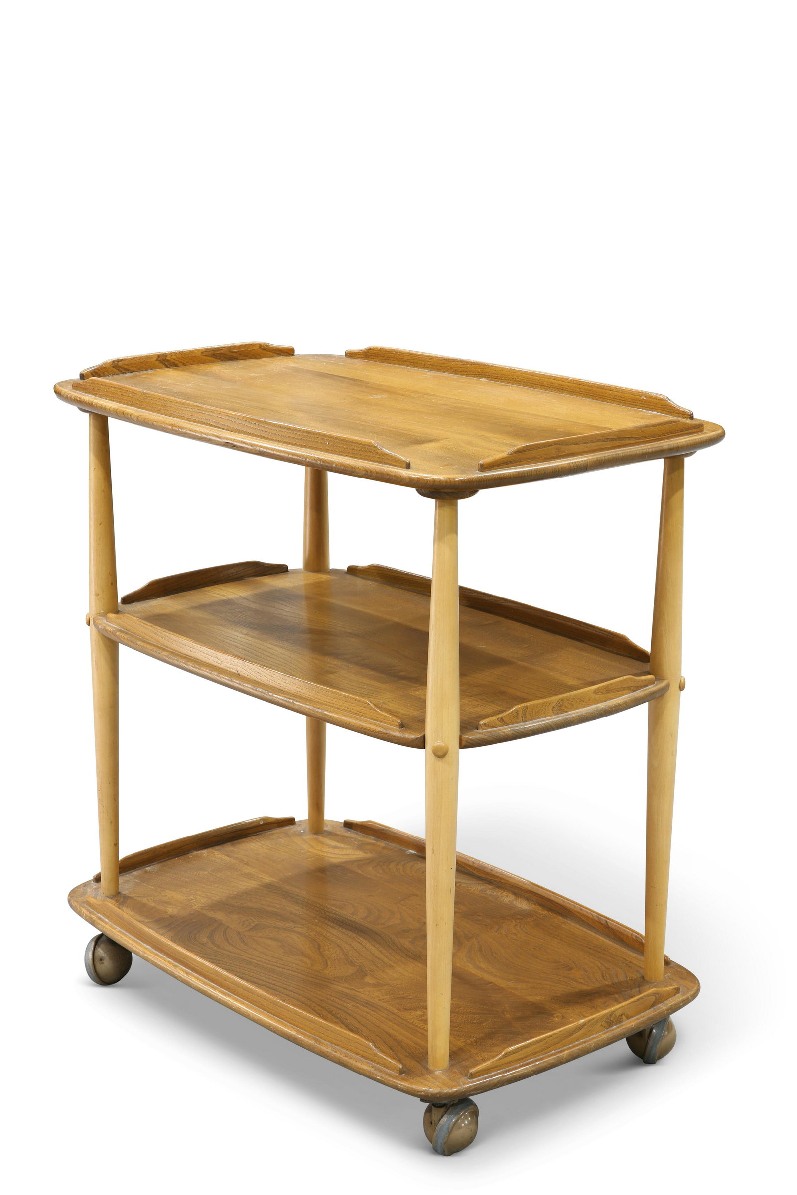 AN ERCOL LIGHT ELM TEA TROLLEY, the three rounded: AN ERCOL LIGHT ELM TEA TROLLEY, the three rounded rectangular tiers supported on reverse tapering columns, moving on castors. 74cm high, 71cm long, 46cm wide