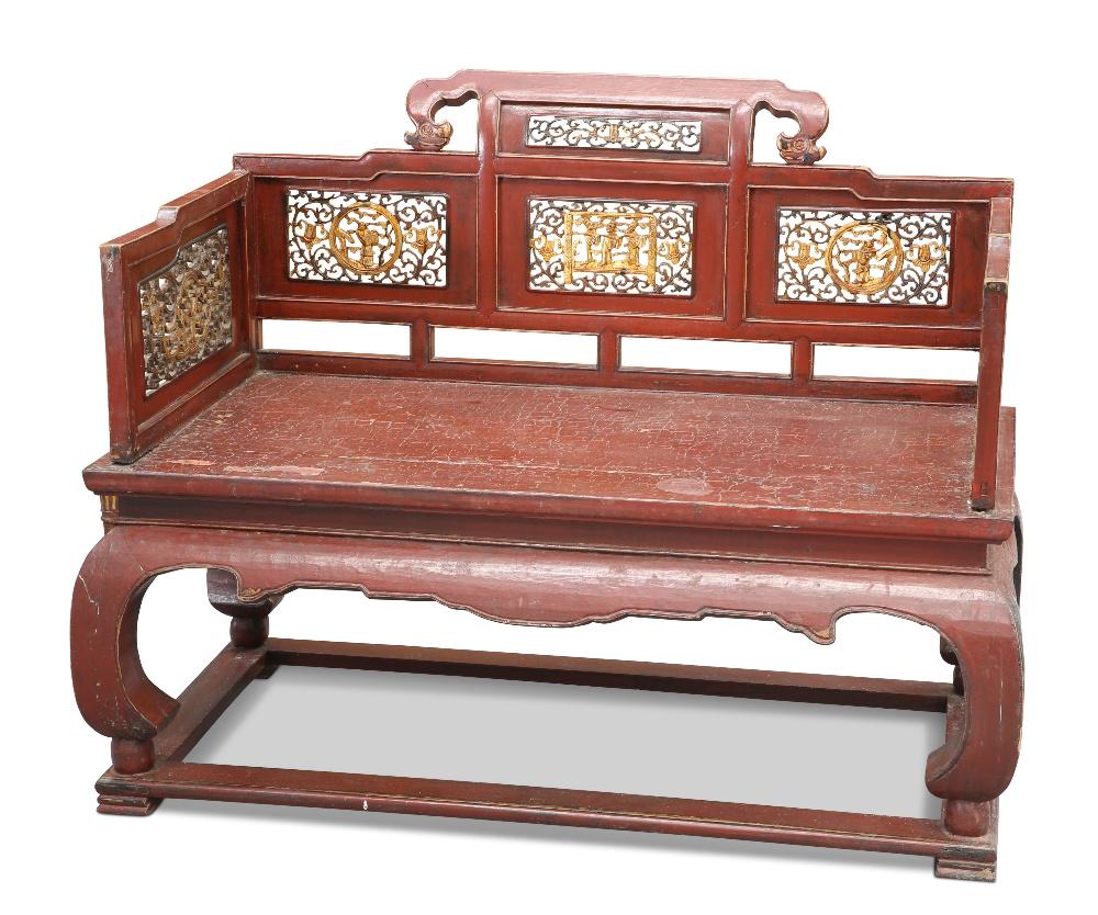 A CHINESE RED LACQUERED BENCH, with gilded fret-carved figural and foliate panels. Height of back 98: A CHINESE RED LACQUERED BENCH, with gilded fret-carved figural and foliate panels. Height of back 98cm, 120cm wide, 69.5cm deep