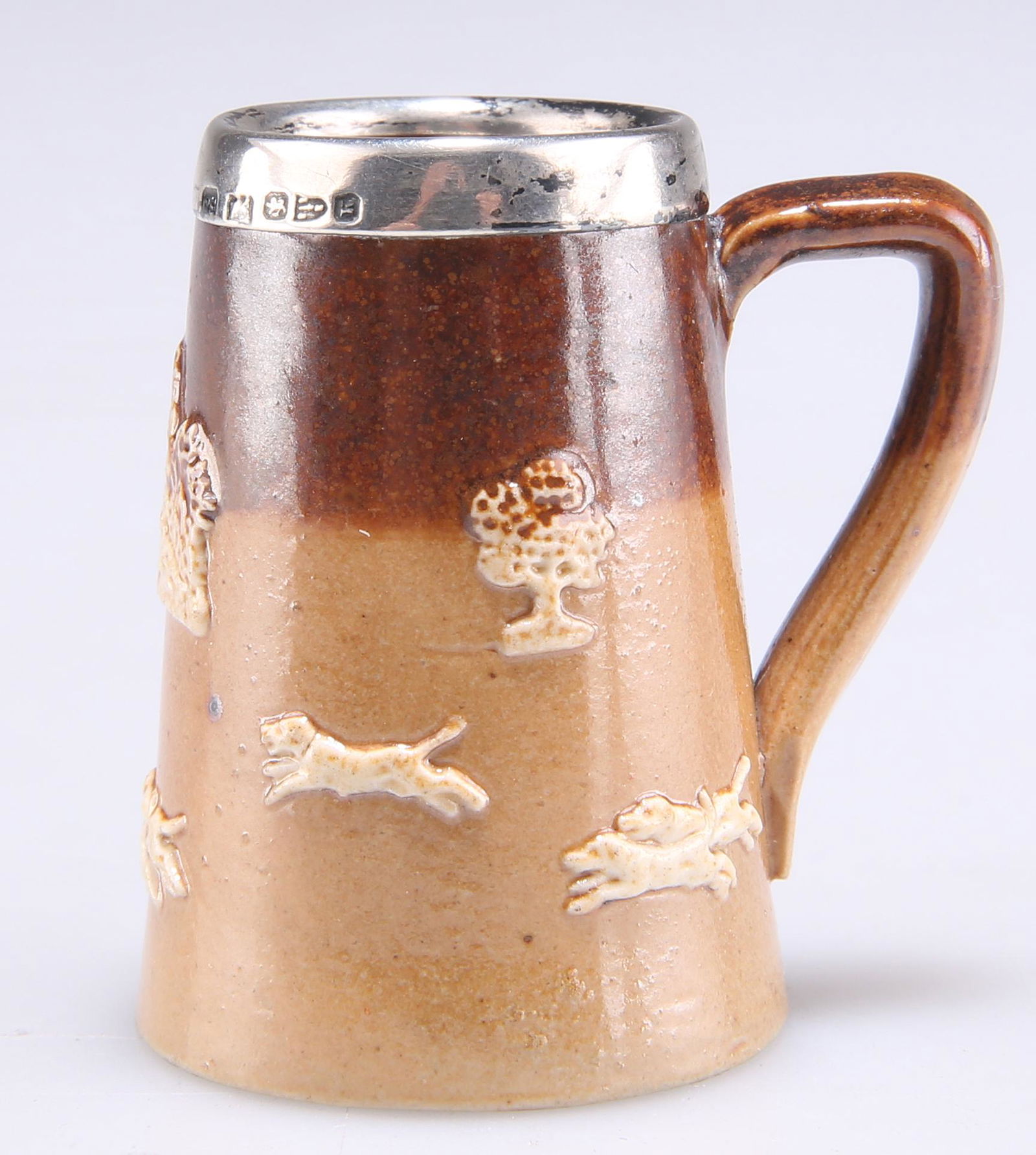 A DOULTON LAMBETH SILVER-MOUNTED MINIATURE TANKARD, Chester 1891, with sprigged decoration of huntin (1 of 1)