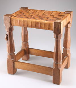 ROBERT THOMPSON OF KILBURN, A MOUSEMAN OAK STOOL, with woven leather strapwork seat, on four octagon: ROBERT THOMPSON OF KILBURN, A MOUSEMAN OAK STOOL, with woven leather strapwork seat, on four octagonal legs, the block feet joined by stretchers, with carved mouse signature. 37.3cm high, 33.9cm wide,