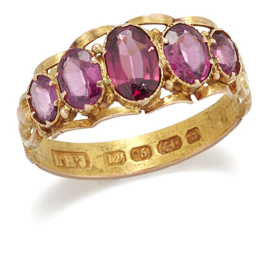 A VICTORIAN 12 CARAT GOLD GARNET RING: A VICTORIAN 12 CARAT GOLD GARNET RING, five graduated oval-cut garnets to a scrolling gallery, pierced shoulders and a foliate engraved shank. Hallmarked Birmingham 1863, ring size O1/2 , 2.1 grams