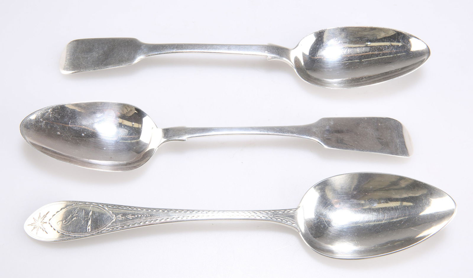 A GROUP OF THREE EARLY 19TH CENTURY IRISH SILVER TABLE SPOONS: A GROUP OF THREE EARLY 19TH CENTURY IRISH SILVER TABLE SPOONS including a bright-cut spoon, by William Ward, Dublin 1807, retailer's mark of W. Peter. (3) Bright-cut spoon 23.5cm long, 6.3 troy ounces