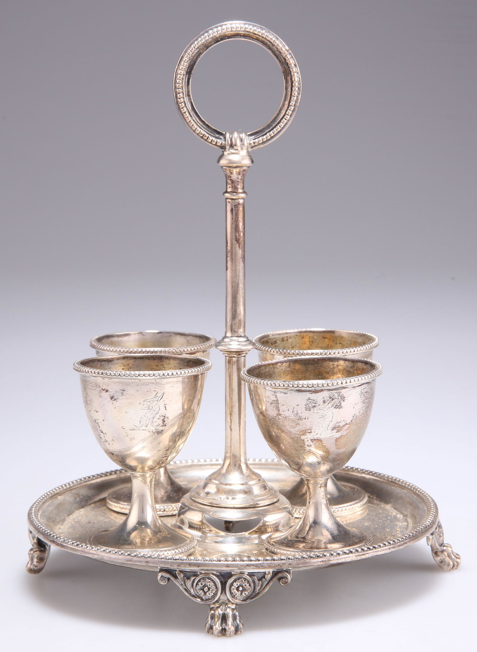 A VICTORIAN SILVER EGG CRUET: A VICTORIAN SILVER EGG CRUET by John, Edward, Walter & John Barnard, London 1869 and 1870, the circular stand with beaded borders, the four egg cups (three 1870) similarly decorated, each piece en