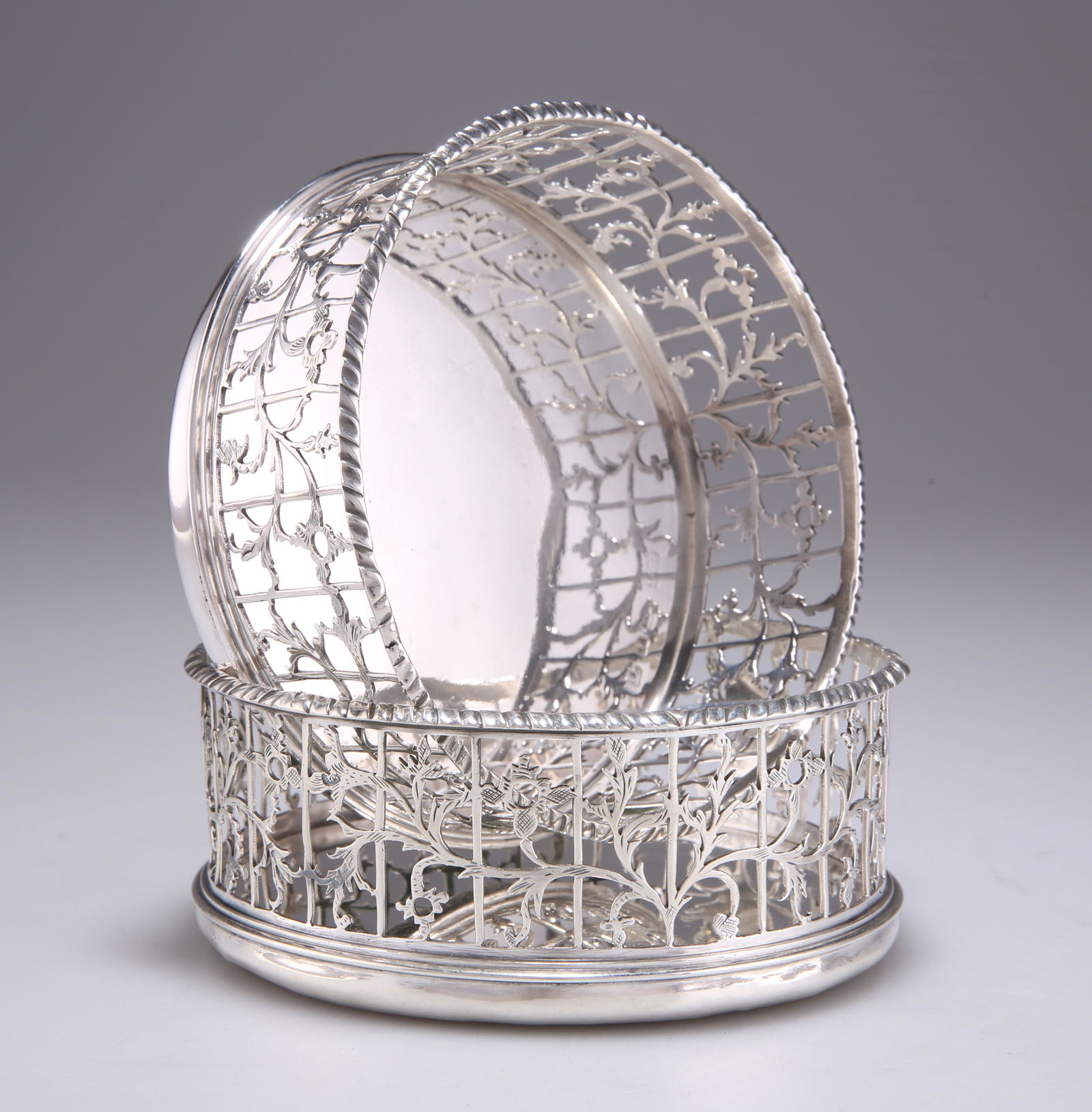A PAIR OF GEORGE III SILVER WINE COASTERS: A PAIR OF GEORGE III SILVER WINE COASTERS by Edward Aldridge II, London 1768, pierced circular form, each engraved with a crest. (2) 11.5cm diameter, 12 troy ounces gross