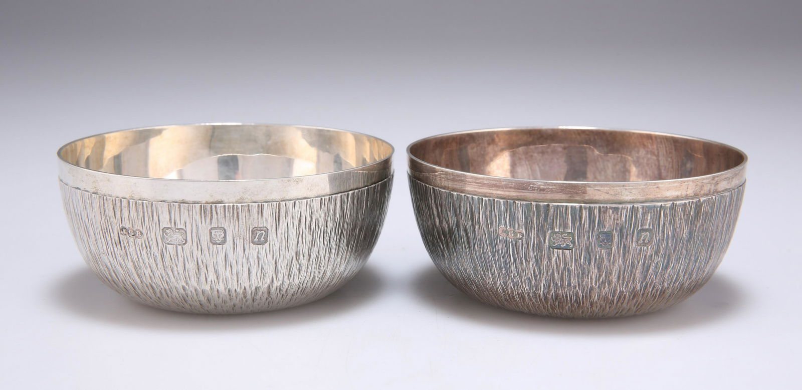 GERALD BENNEY: A PAIR OF ELIZABETH II SILVER BOWLS: GERALD BENNEY: A PAIR OF ELIZABETH II SILVER BOWLS by Gerald Benney, London 1968, circular with bark effect texturing, signed GERALD BENNEY LONDON to underside. (2) 9.1cm diameter, 7.8 troy ounces gro