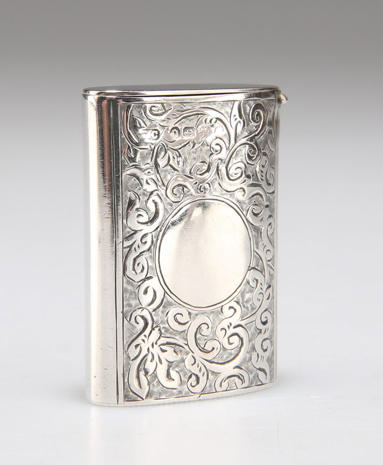 A LATE VICTORIAN SILVER VESTA CASE: A LATE VICTORIAN SILVER VESTA CASE by John Culver (probably), Birmingham 1888, of unusual elliptical shape, finely engraved each side with a panel of scrolling foliage, one centred by a vacant roundel