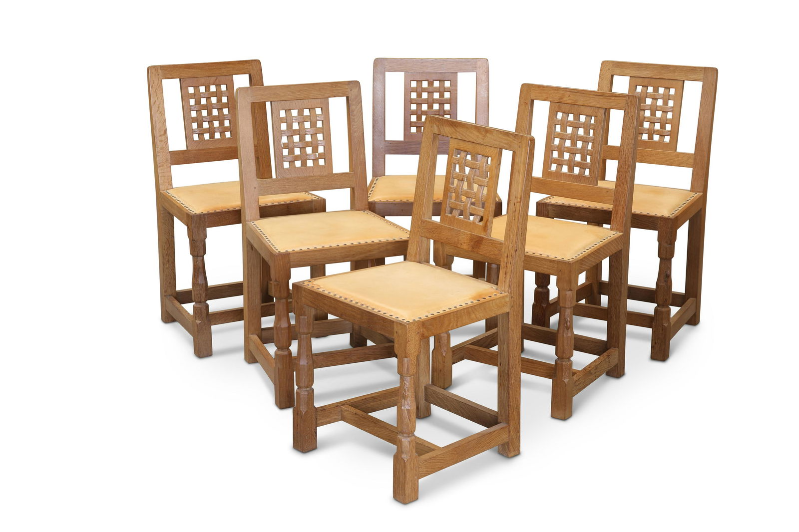 ROBERT THOMPSON OF KILBURN, A SET OF SIX MOUSEMAN OAK DINING CHAIRS: ROBERT THOMPSON OF KILBURN, A SET OF SIX MOUSEMAN OAK DINING CHAIRS each with lattice back and faceted baluster legs continuing to blocks joined by stretchers, with carved mouse signature. (6) Height