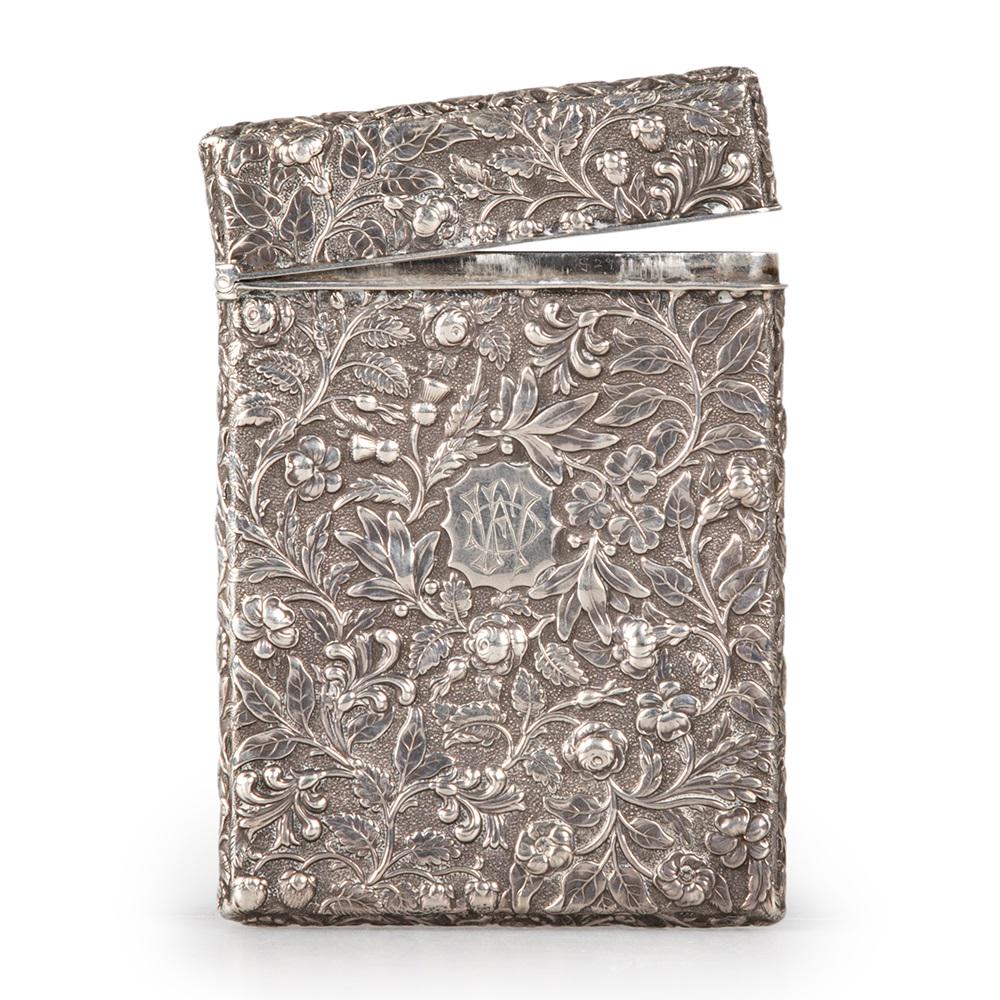 A VICTORIAN SILVER CARD CASE: A VICTORIAN SILVER CARD CASE by John Yapp & John Woodward, Birmingham 1848, heavily chased all-over with scrolling foliage, flowerheads and thistle heads to a stippled ground, with a shaped cartou