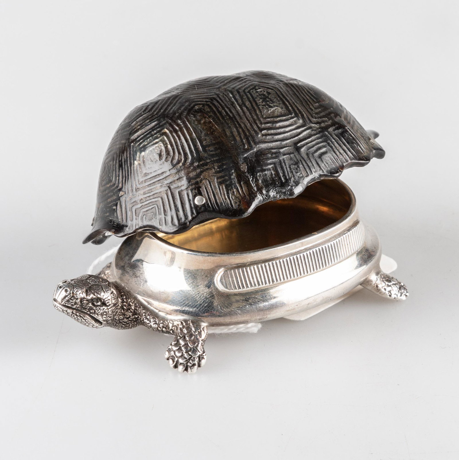 A VICTORIAN SILVER AND TORTOISESHELL VESTA CASE: A VICTORIAN SILVER AND TORTOISESHELL VESTA CASE by Thomas Johnson II, London 1881, realistically modelled as a tortoise, the silver body with hinged tortoiseshell shell, gilded interior. 9cm long, 2.5