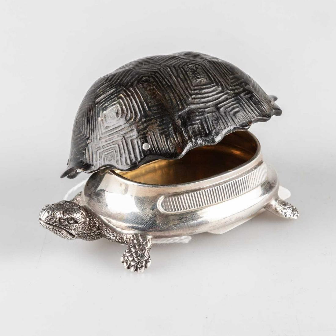 A VICTORIAN SILVER AND TORTOISESHELL VESTA CASE: A VICTORIAN SILVER AND TORTOISESHELL VESTA CASE by Thomas Johnson II, London 1881, realistically modelled as a tortoise, the silver body with hinged tortoiseshell shell, gilded interior. 9cm long, 2.5