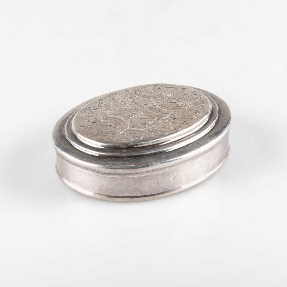 A GEORGE II SILVER TOBACCO BOX: A GEORGE II SILVER TOBACCO BOX by James Smith I, London 1735, oval, the cover with an armorial within foliate scroll mantling, the underside of the base engraved T*P. 10cm wide, 4.5 troy ounces