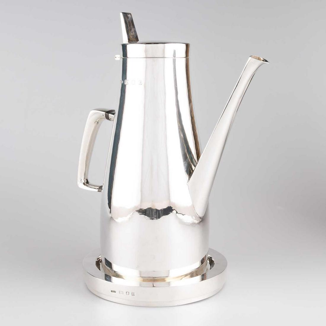 AN ELIZABETH II SILVER COFFEE POT ON STAND: AN ELIZABETH II SILVER COFFEE POT ON STAND by Gerald Benney, London 1965, of large size, the plain baluster body with hinged cover and stylised tapering spout, on a silver circular stand. 30cm high, 5
