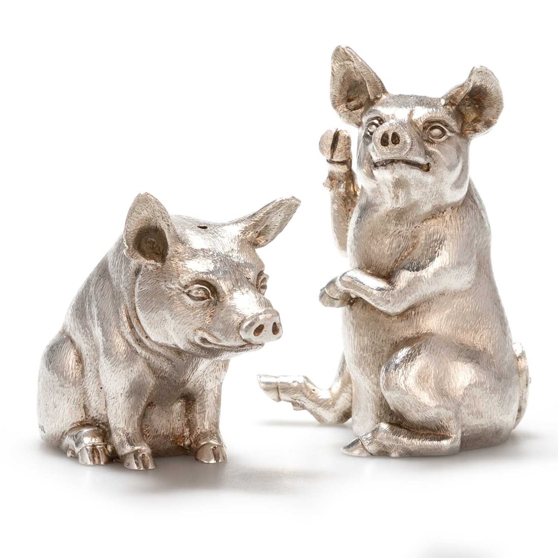 AN ELIZABETH II SILVER NOVELTY SALT AND PEPPERETTE: AN ELIZABETH II SILVER NOVELTY SALT AND PEPPERETTE by William Comyns & Sons Ltd (Richard Comyns), London 1990, both modelled as pigs. (2) Taller pig 9cm high, 16.4 troy ounces gross Good conditio