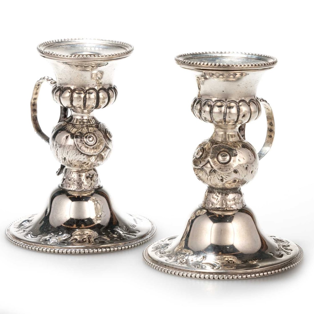 A PAIR OF VICTORIAN SILVER NOVELTY CHAMBERSTICKS: A PAIR OF VICTORIAN SILVER NOVELTY CHAMBERSTICKS by Robert Harper, London 1859, each with a beaded detachable nozzle above a partially reeded sconce supported on the head of an owl, all raised on a do
