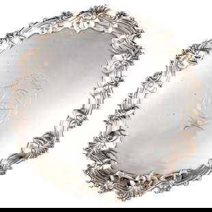 A GEORGE II SILVER SALVER: A GEORGE II SILVER SALVER by William Grundy, London 1754, of shaped circular-form, raised on three leaf-capped scroll feet, with shell and scroll border, engraved with a coat of arms. 38.5cm diameter,