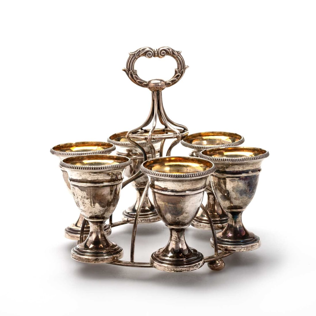 A GEORGE III SILVER EGG CRUET: A GEORGE III SILVER EGG CRUET by Samuel Roberts, George Cadman & Co, Sheffield 1819, circular form, with six egg cups, each gilt lined with a gadrooned edge. 16.5cm high, 15.8 troy ounces gross g