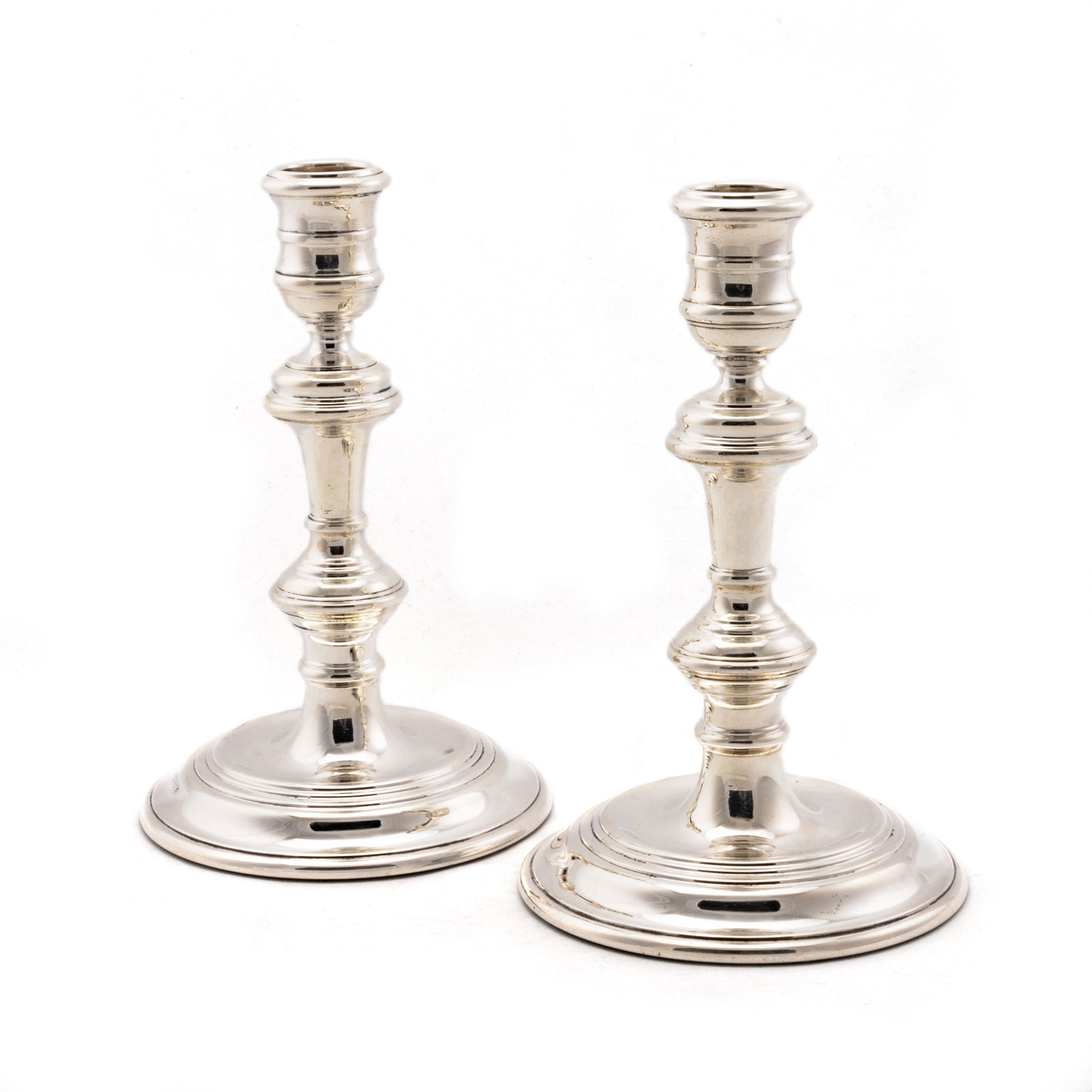 A PAIR OF ELIZABETH II SILVER CANDLESTICKS: A PAIR OF ELIZABETH II SILVER CANDLESTICKS by William Comyns & Sons Ltd (Richard Comyns), London 1962, both with urn-shaped sconces and knopped stems raised on circular stepped bases, weighted. (2