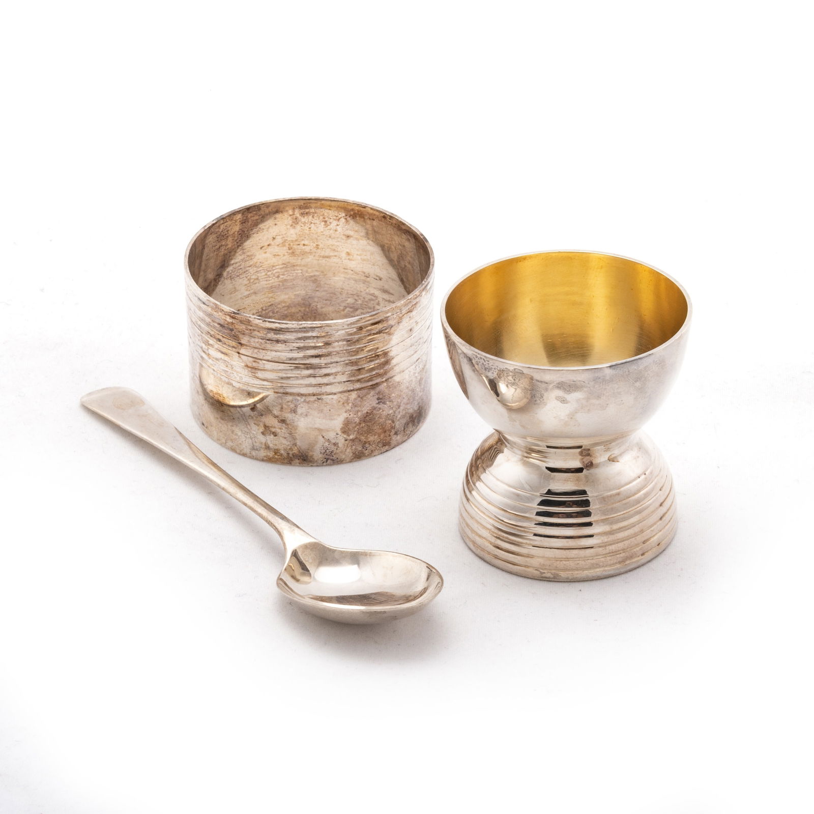 AN ART DECO SILVER CHRISTENING SET: AN ART DECO SILVER CHRISTENING SET the napkin ring and spoon by S Blanckensee & Son Ltd, Chester 1939, the egg cup by the same maker, Birmingham 1938, cased. Egg cup 4.2cm high, 2 troy ounces gros