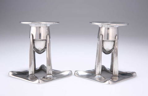 ARCHIBALD KNOX (1864-1933) FOR LIBERTY & CO, A PAIR OF TUDRIC PEWTER CANDLESTICKS: ARCHIBALD KNOX (1864-1933) FOR LIBERTY & CO, A PAIR OF TUDRIC PEWTER CANDLESTICKS no. 0222, each with a bullet shaped sconce with a wide circular drip-pan, raised on four supports issuing from a shape