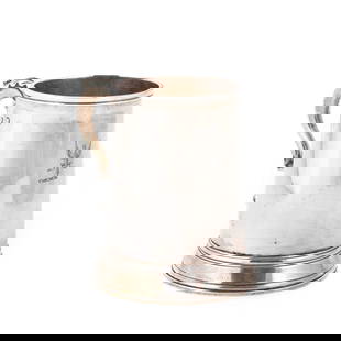 A GEORGE III SILVER MUG: A GEORGE III SILVER MUG by Hester Bateman, London 1786, of straight-sided tapering form, with a leaf-capped double scroll handle, engraved with a crest. 10.5cm high, 7.7 troy ounces The maker's mark