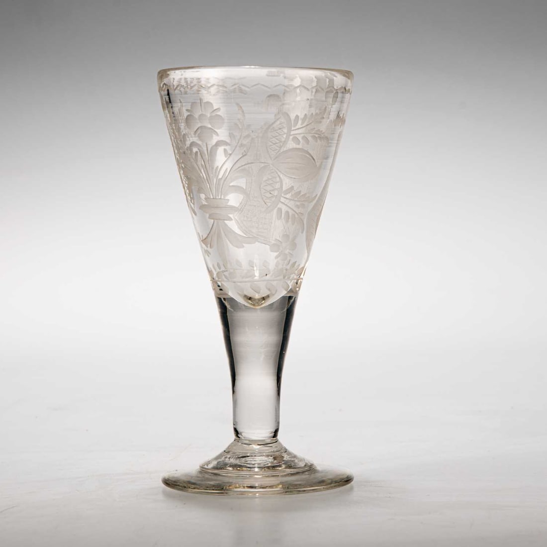 A DUTCH ARMORIAL GOBLET, CIRCA 1770: A DUTCH ARMORIAL GOBLET, CIRCA 1770 the trumpet bowl engraved with the arms of Amsterdam, to the reverse flowers, raised on an unusually stepped and conical foot. 17.4cm high