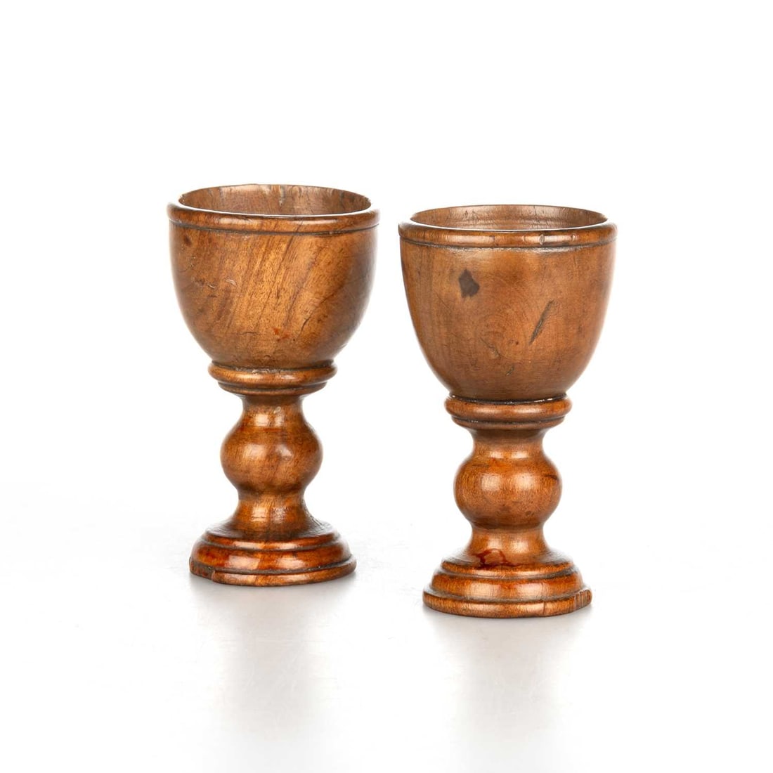 A PAIR OF 19TH CENTURY TREEN EGG CUPS: A PAIR OF 19TH CENTURY TREEN EGG CUPS each with knopped stem. (2) 8cm high