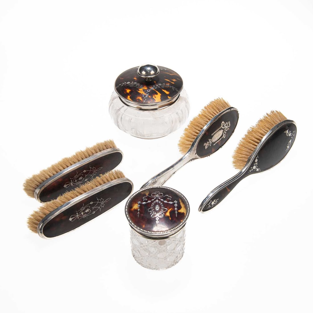 A GROUP OF SILVER, TORTOISESHELL AND CUT-GLASS VANITY ITEMS: A GROUP OF SILVER, TORTOISESHELL AND CUT-GLASS VANITY ITEMS comprising two clothes brushes by Collett & Anderson, London 1908, two hair brushes and two jars with covers, each silver-mounted and w