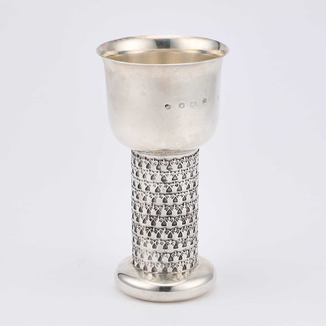 AN ELIZABETH II SILVER GOBLET: AN ELIZABETH II SILVER GOBLET by Jack Spencer (Silversmith) Ltd, Sheffield 1973, the round bowl with an everted rim, on a cylindrical stem with a repeating pattern, issuing from a disc foot. 14.6cm hi