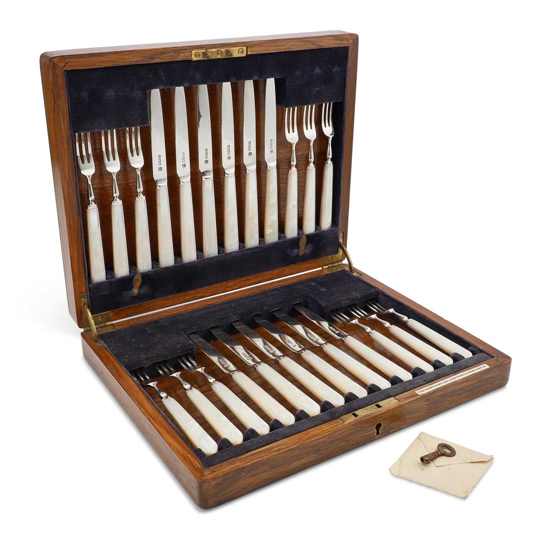A SET OF GEORGE V SILVER AND MOTHER-OF-PEARL FRUIT KNIVES AND FORKS: A SET OF GEORGE V SILVER AND MOTHER-OF-PEARL FRUIT KNIVES AND FORKS by Northern Goldsmiths Co, Sheffield 1926, comprising twelve knives and twelve forks, in a fitted oak case. (24) Knives 17.5cm long,