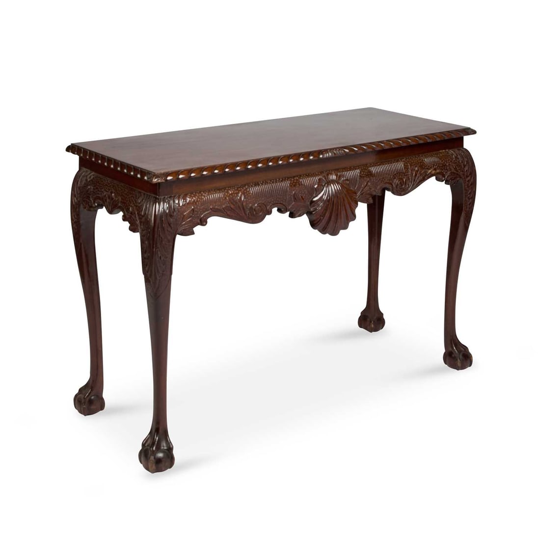 A MAHOGANY SERVING TABLE IN GEORGE II IRISH STYLE: A MAHOGANY SERVING TABLE IN GEORGE II IRISH STYLE the rectangular top with a gadrooned edge over a leaf-carved frieze, raised on cabriole legs terminating in ball and claw feet. 79cm high, 121cm long,