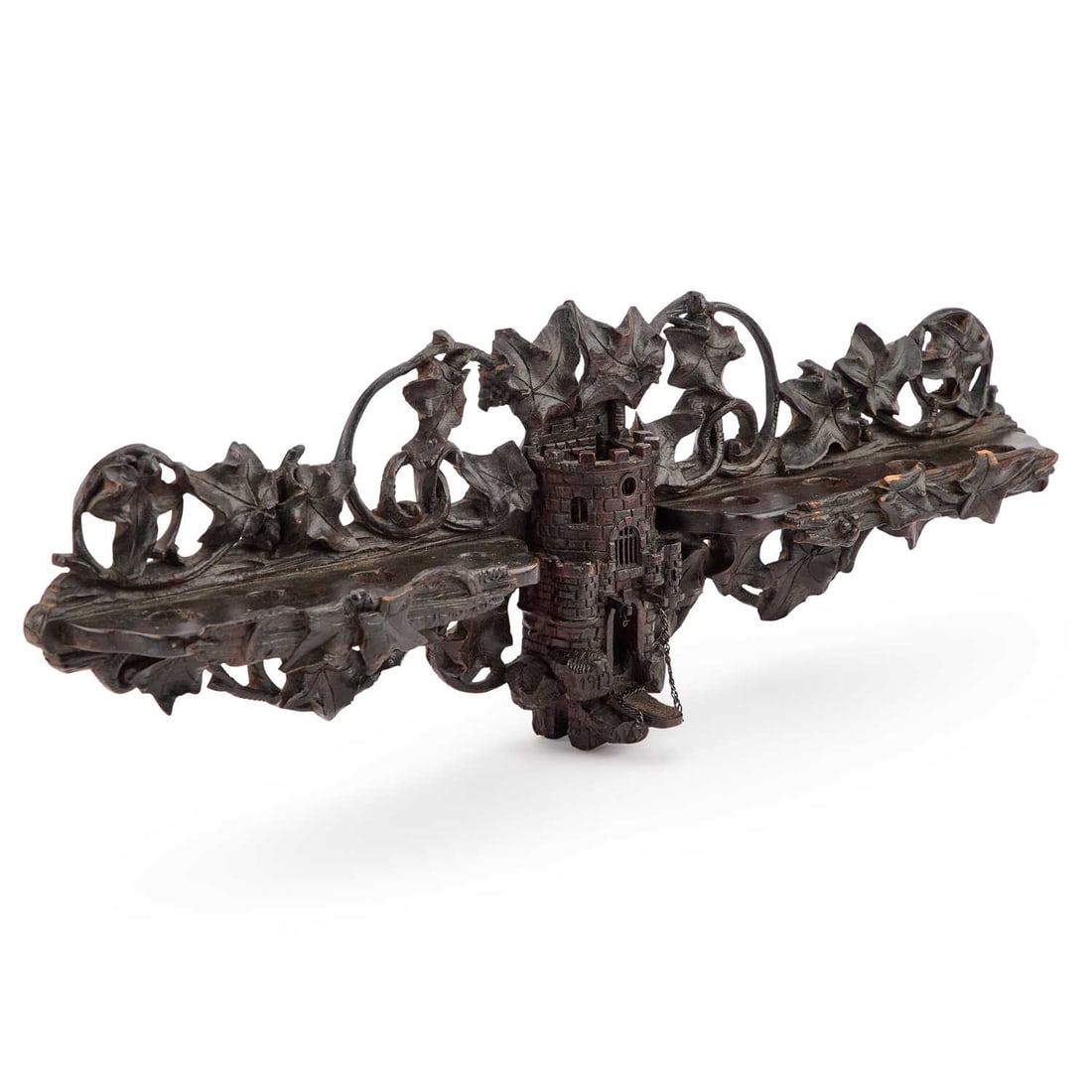 A BLACK FOREST PIPE RACK, DATED 1912: A BLACK FOREST PIPE RACK, DATED 1912 centred by a castle turret flanked by two shelves, each can accommodate four pipes, the crest and apron pierced and carved with scrolling fruiting foliage. 53cm lo