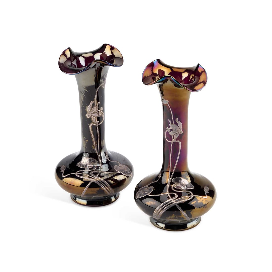 A PAIR OF ART NOUVEAU SILVER OVERLAID GLASS VASES, IN THE STYLE OF LOETZ: A PAIR OF ART NOUVEAU SILVER OVERLAID GLASS VASES, IN THE STYLE OF LOETZ the iridescent dark purple glass with an undulating flared rim, decorated with a foliate design interlaced with silver overlay.