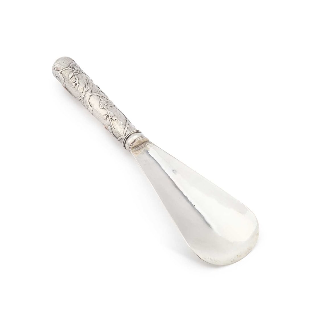 A CHINESE SILVER SHOE-HORN: A CHINESE SILVER SHOE-HORN unmarked, the handle decorated with a bird and prunus blossom. 22cm long, 2.7 troy ounces gross