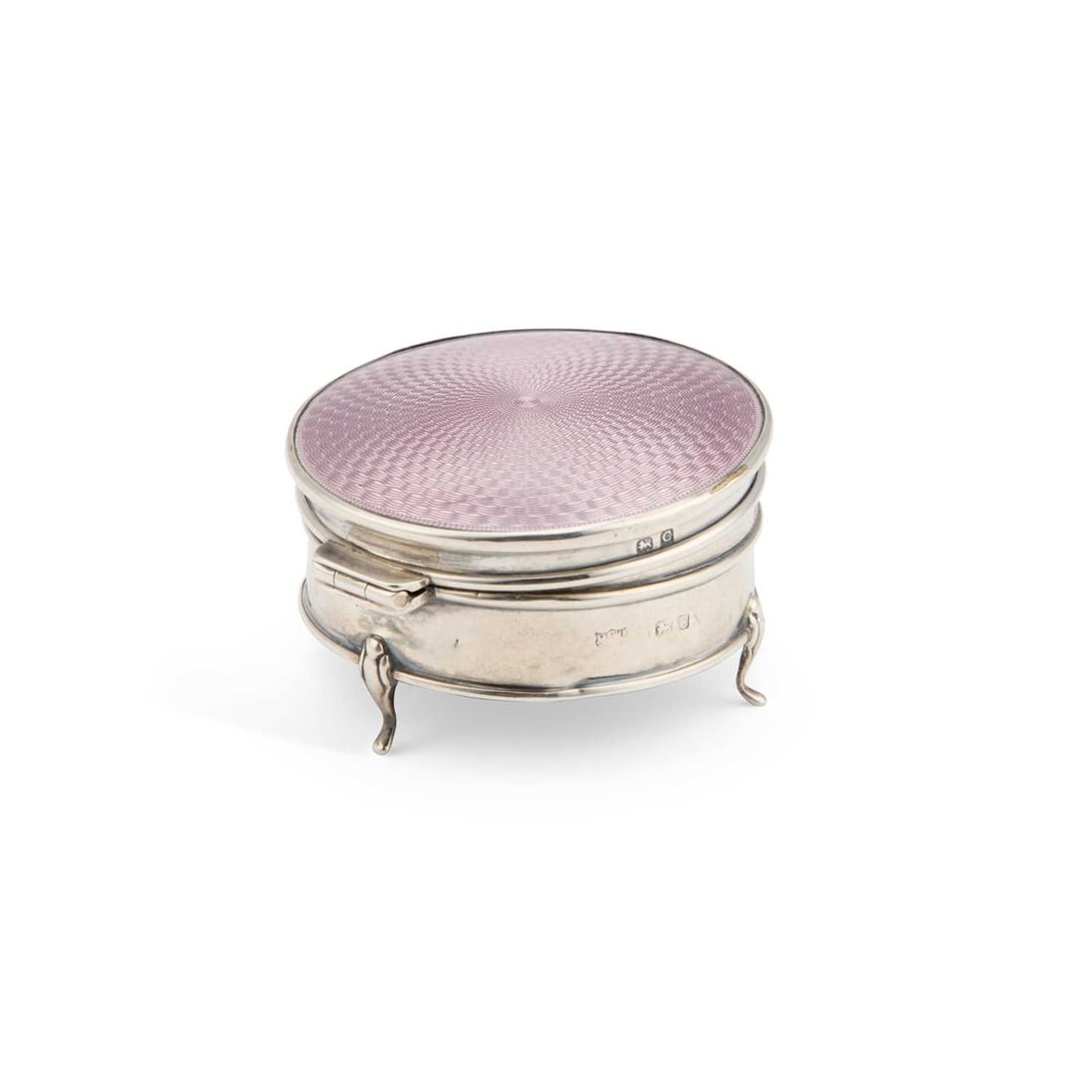 A GEORGE V SILVER AND ENAMEL RING BOX: A GEORGE V SILVER AND ENAMEL RING BOX by Mappin & Webb Ltd, Birmingham 1927, circular with three scroll feet, the hinged cover decorated with lilac guilloche enamel. 6.5cm diameter, 2.6 troy ounce