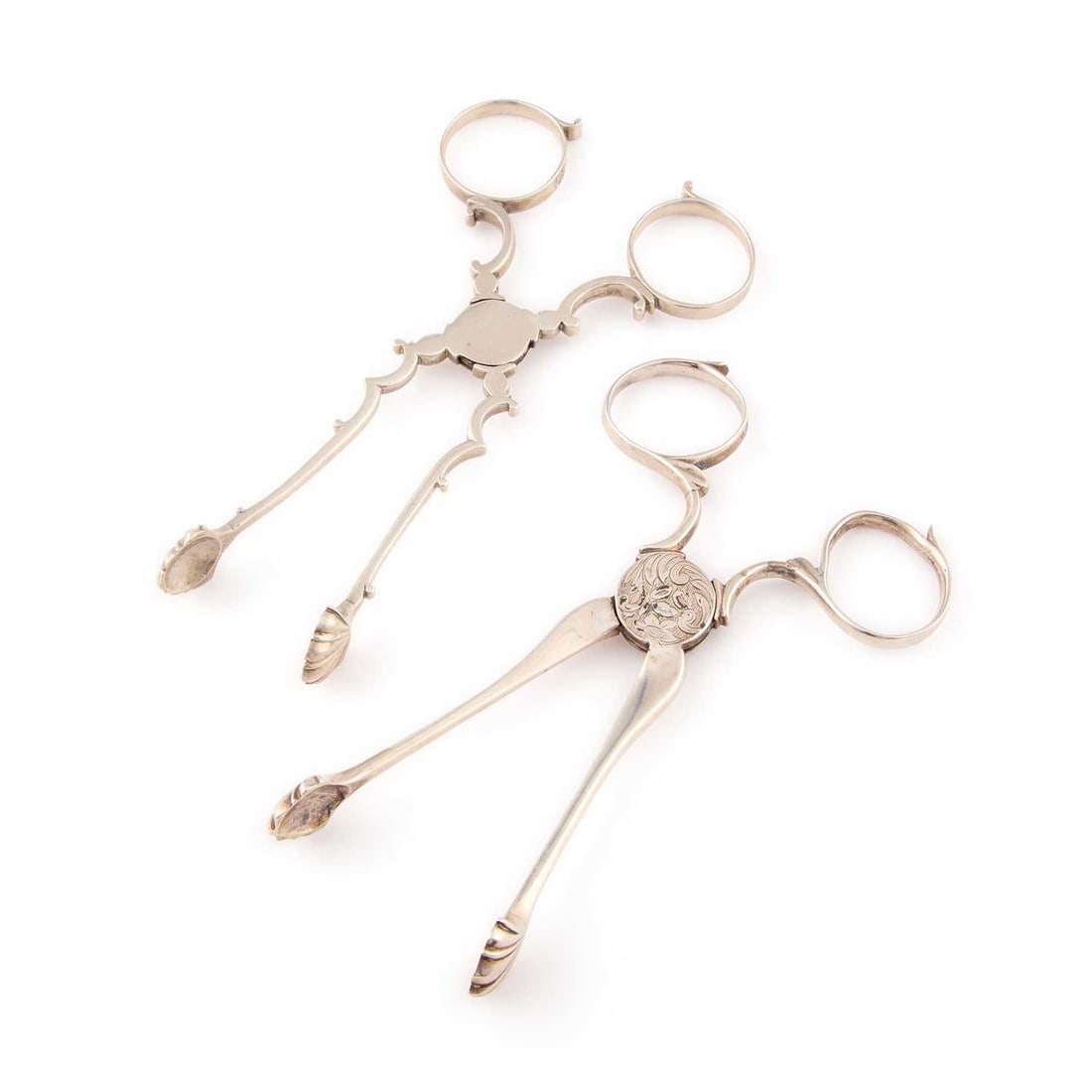 TWO PAIRS OF GEORGE III SILVER SUGAR TONGS: TWO PAIRS OF GEORGE III SILVER SUGAR TONGS the first pair by William Harrison I, London, c.1770; the second pair probably by Richard Meach, London, c.1765. (2) Longest 12.2cm, 2 troy ounces gross