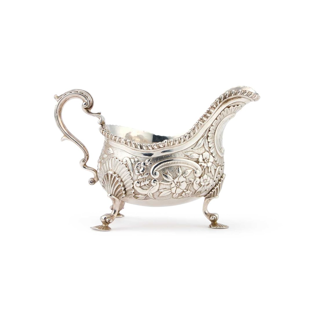 A LARGE VICTORIAN SILVER SAUCEBOAT: A LARGE VICTORIAN SILVER SAUCEBOAT by Charles Stuart Harris, London 1890, the C-scroll handle with a leaf-form thumbpiece, raised on shell-capped scroll feet terminating in shell-form pads, boldly cha