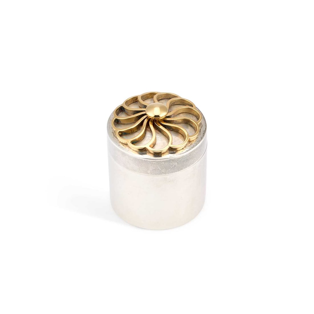 A MODERNIST SILVER AND SILVER-GILT BOX: A MODERNIST SILVER AND SILVER-GILT BOX by Jack Spencer (Silversmith) Ltd, Sheffield 1995, cylindrical, the pull-off cover with an openwork flowerhead motif. 5.3cm high, 2.1 troy ounces