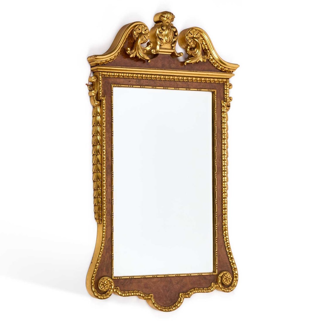 A PARCEL-GILT WALNUT MIRROR 20TH CENTURY, IN THE STYLE OF WILLIAM KENT: A PARCEL-GILT WALNUT MIRROR 20TH CENTURY, IN THE STYLE OF WILLIAM KENT the crest with scrolling foliage. 105cm high, 61cm wide