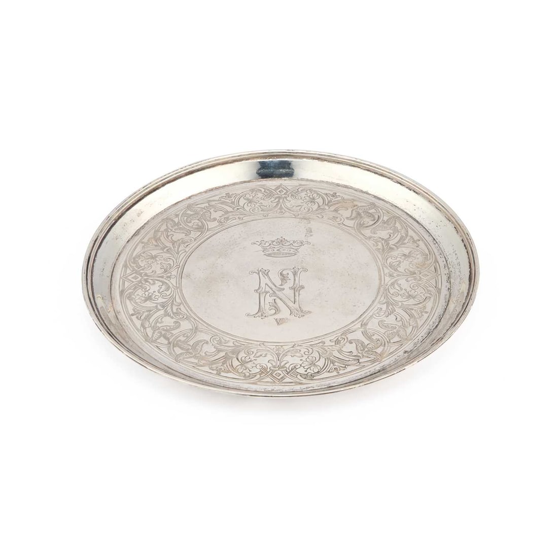 A RUSSIAN SILVER SALVER: A RUSSIAN SILVER SALVER First Kokoshnik mark, c.1896-1908, of circular form with a reeded edge, engraved with a coronet and initial N within a broad border of scrolling foliage. 19cm diameter, 6.4 tro