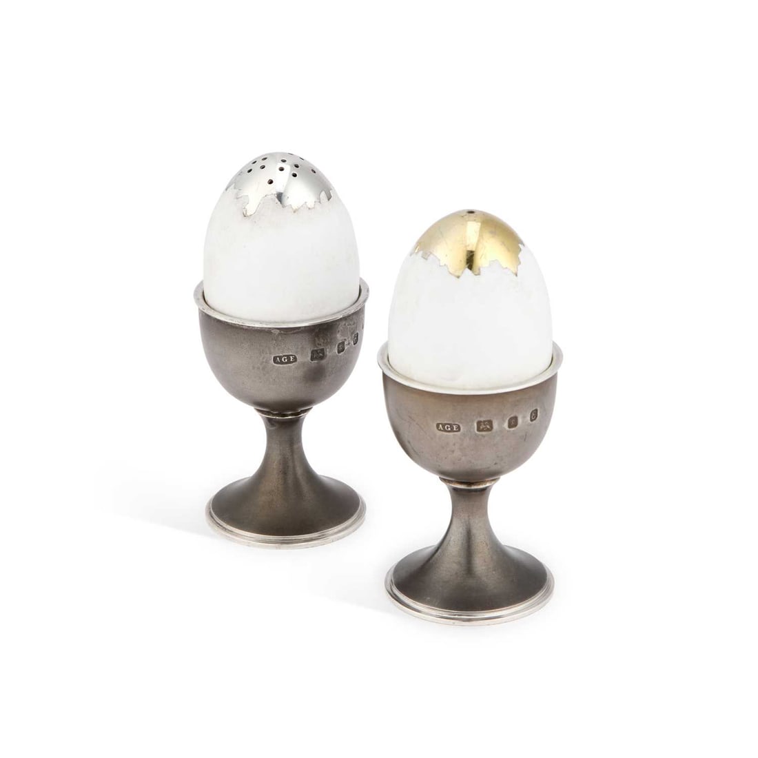 ANTHONY GORDON ELSON: A PAIR OF ELIZABETH II SILVER AND ENAMEL NOVELTY SALT AND PEPPER POTS: ANTHONY GORDON ELSON: A PAIR OF ELIZABETH II SILVER AND ENAMEL NOVELTY SALT AND PEPPER POTS by Anthony Gordon Elson, London 1979, each modelled as an egg in an egg cup. (2) 10.5cm high, 8.7 troy ounce
