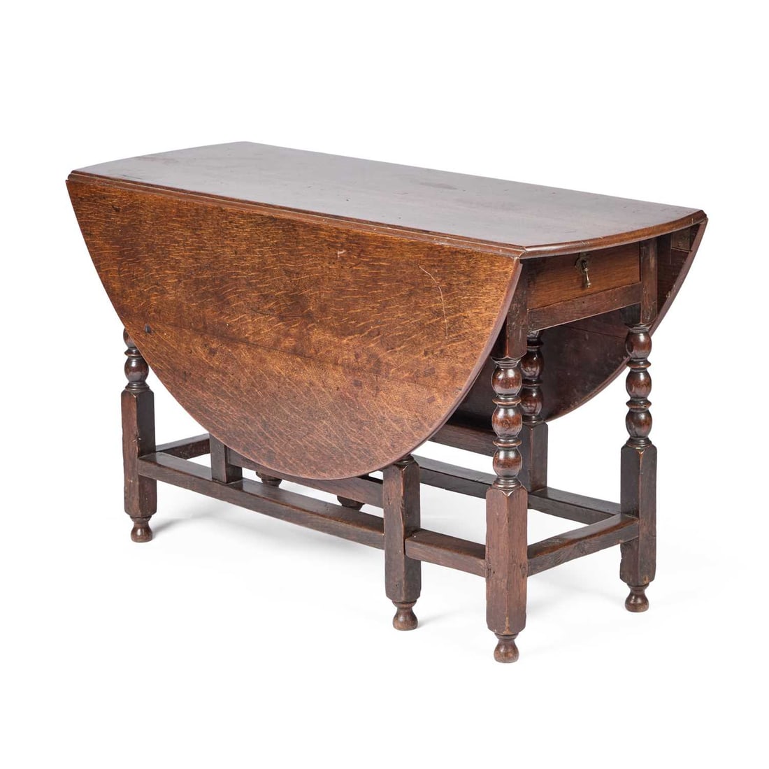 AN OAK GATELEG DINING TABLE LATE 17TH/EARLY 18TH CENTURY: AN OAK GATELEG DINING TABLE LATE 17TH/EARLY 18TH CENTURY the oval top above a frieze drawer to one end, raised on bobbin-turned and block legs, joined by stretchers. 70.5cm high, top 133cm by 121cm Th