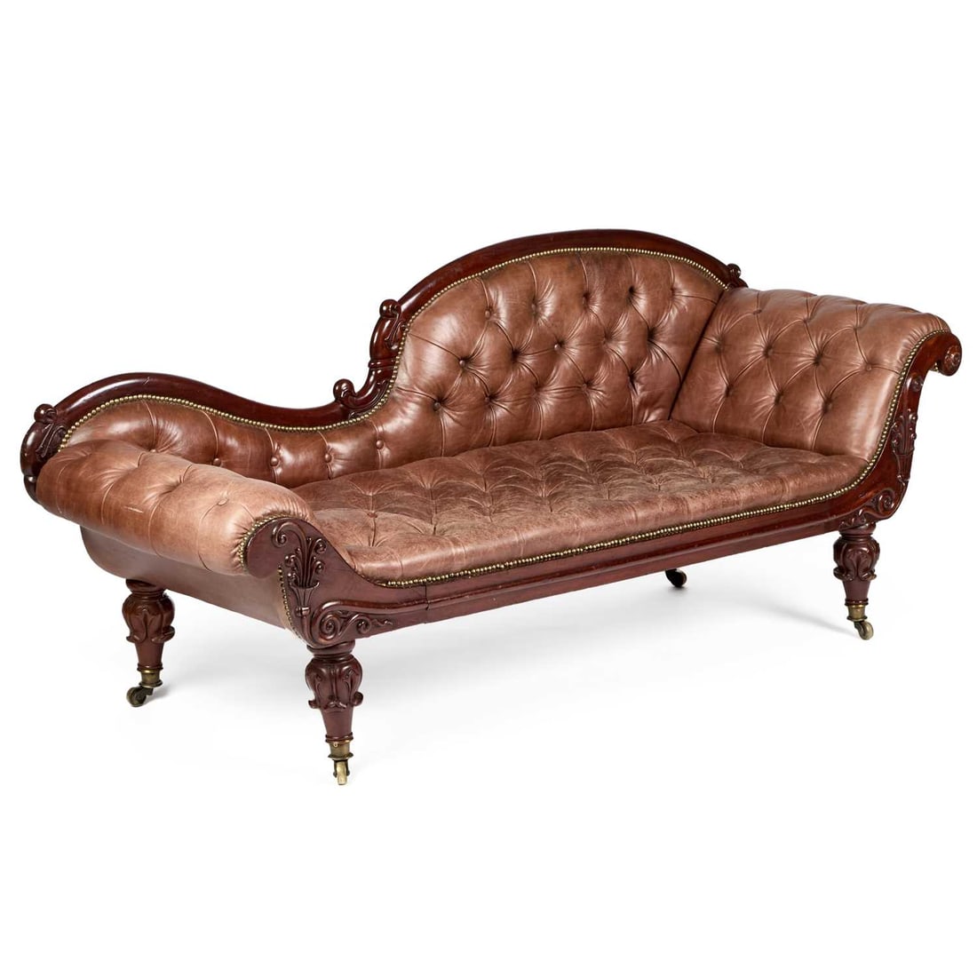 A WILLIAM IV MAHOGANY AND BROWN LEATHER UPHOLSTERED CHAISE LONGUE: A WILLIAM IV MAHOGANY AND BROWN LEATHER UPHOLSTERED CHAISE LONGUE with deep-buttoned upholstery and scroll ends, raised on leaf-carved legs, moving on castors. 180cm long