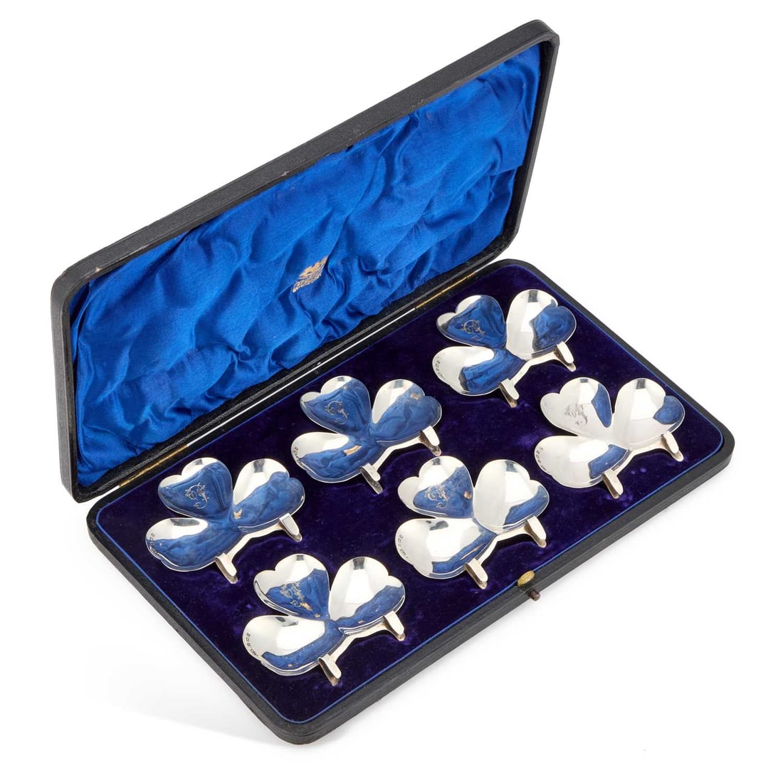 A CASED SET OF SIX EDWARDIAN SILVER CLOVER LEAF PLATE CLIPS: A CASED SET OF SIX EDWARDIAN SILVER CLOVER LEAF PLATE CLIPS by Harry Hayes, Birmingham 1905, each engraved with an initial. (6) 7.5cm wide, 3.3 troy ounces gross