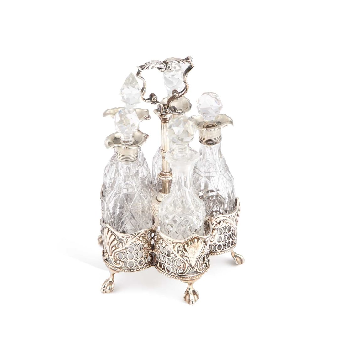 A VICTORIAN SILVER FIVE-BOTTLE CRUET STAND: A VICTORIAN SILVER FIVE-BOTTLE CRUET STAND by Charles Thomas Fox & George Fox, London 1852, the stand with a leaf-capped handle and pierced sides chased with shells and scrolls, raised on ball and