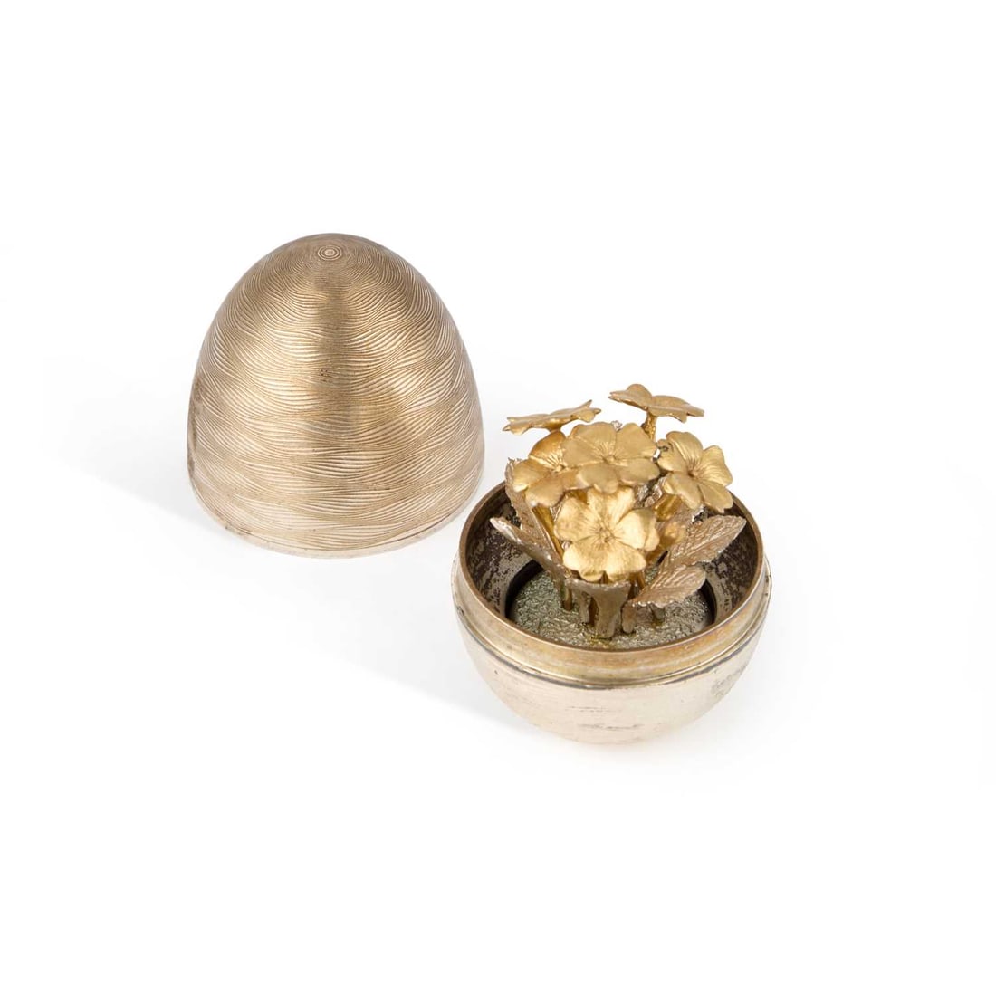 AN ELIZABETH II SILVER SURPRISE EGG: AN ELIZABETH II SILVER SURPRISE EGG by Nicholas Plummer, London 2000, with an engraved exterior, the interior with a bouquet of flowers. 6cm high, 3.3 troy ounces