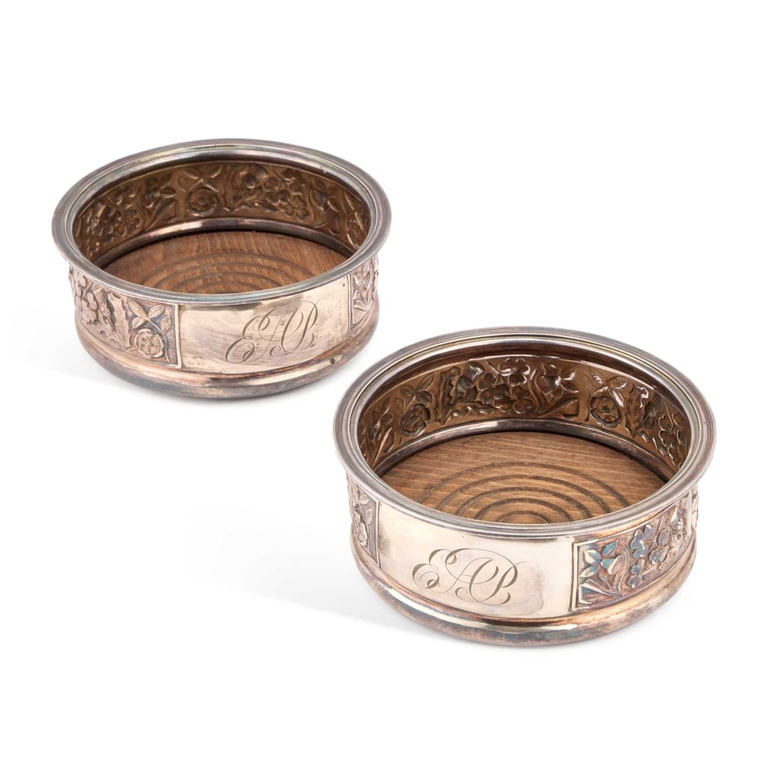 A PAIR OF ELIZABETH II SILVER BOTTLE COASTERS: A PAIR OF ELIZABETH II SILVER BOTTLE COASTERS by Roberts & Belk Ltd, Sheffield 1977, with a Jubilee mark, chased with roses, shamrocks, thistles and daffodils, emblems of the four British nations,