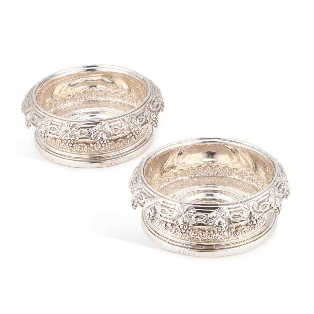 A PAIR OF GEORGE IV SILVER WINE COASTERS: A PAIR OF GEORGE IV SILVER WINE COASTERS by S C Younge & Co, Sheffield 1827, of circular form, each everted rim chased with bunches of grapes and vines, the bases engraved with flowers and scrolls
