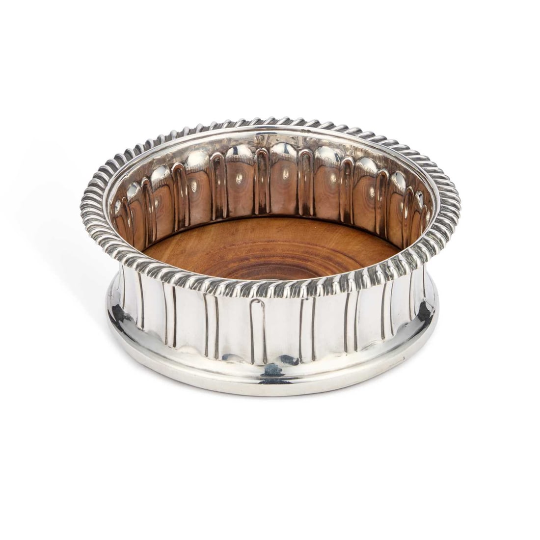 AN EARLY VICTORIAN SILVER WINE COASTER: AN EARLY VICTORIAN SILVER WINE COASTER by Edward, Edward junior, John & William Barnard, London 1843, of circular form with a gadrooned rim and fluted side, the turned wooden base centred by a cre