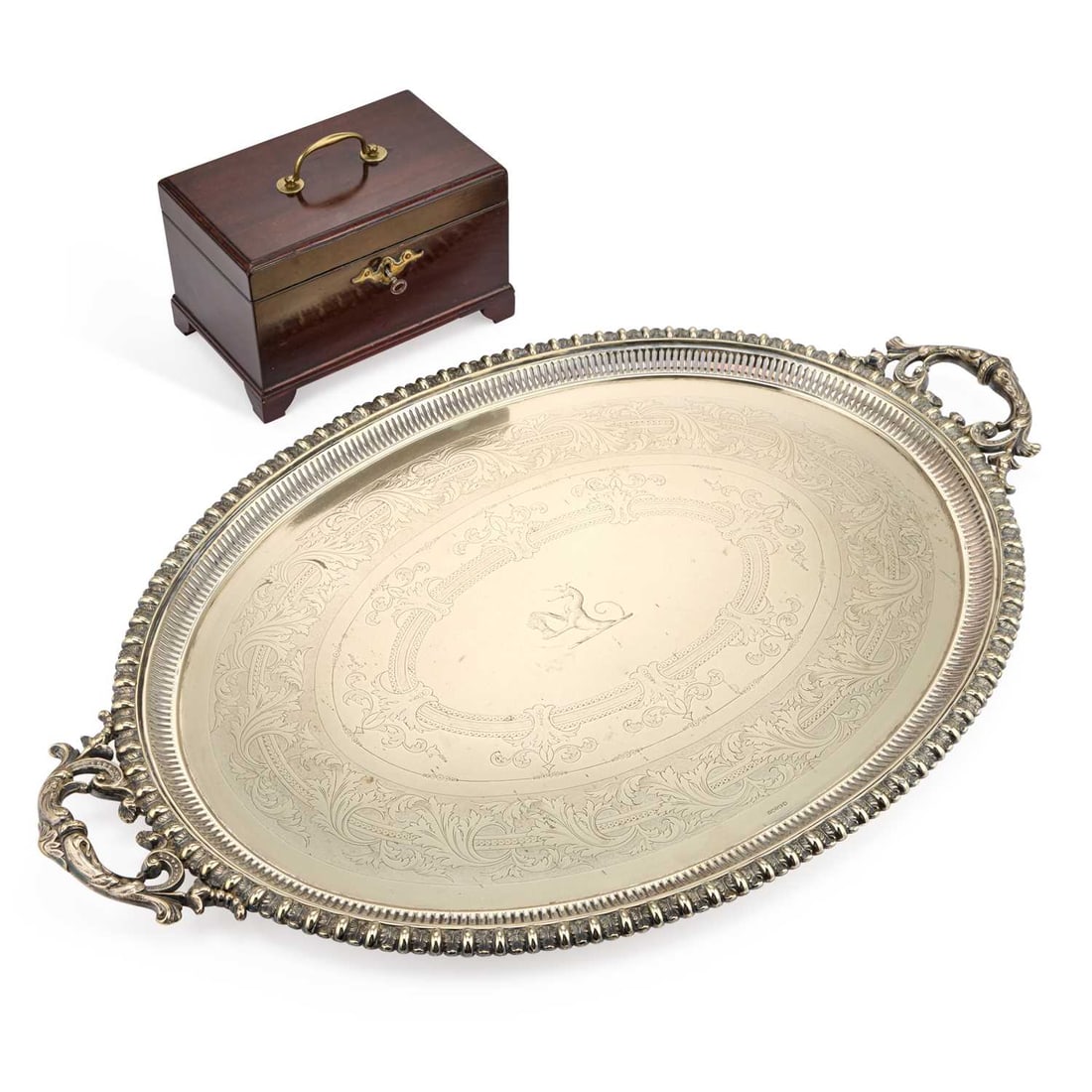 A LARGE VICTORIAN SILVER-PLATED TWO-HANDLED OVAL TRAY: A LARGE VICTORIAN SILVER-PLATED TWO-HANDLED OVAL TRAY with a bold leaf and reel border, engraved with a crest; together with a George III mahogany tea caddy. (2) Tray 75cm long, 48cm wide